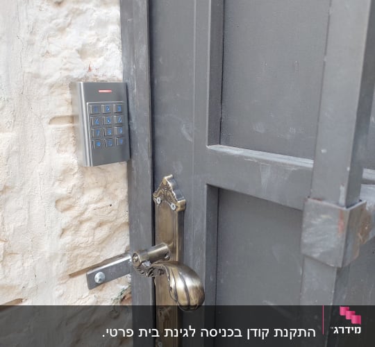 לוח מקשים מתכת ליד דלת אפורה